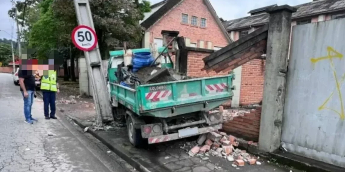 Caminhão causa danos ao atingir poste e muro, em Blumenau